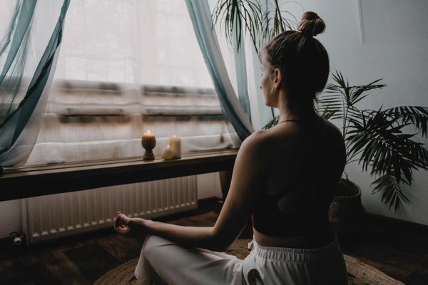 Woman meditating in a bright Los Angeles apartment during anxiety therapy