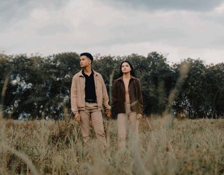 Man and woman in Los Angeles seeking attachment therapy in Los Angeles. They look angry, standing in a Griffith Park meadow wearing brown jackets.