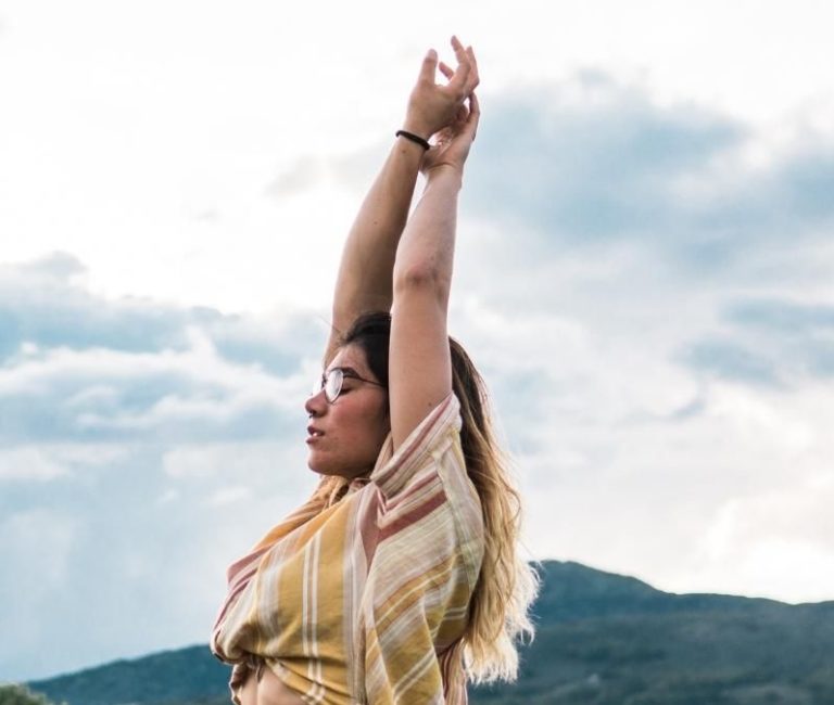 A woman meditating and stretching at Griffith Park in Los Angeles, practicing somatic trauma therapy techniques for nervous system healing and body awareness.