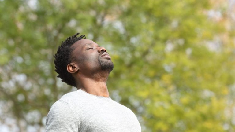Man with eyes closed and relaxed in Los Angeles. Man is wearing white shirt, and feels healed after internal family systems therapy in Los Angeles