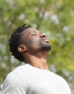 Man with eyes closed and relaxed in Los Angeles. Man is wearing white shirt, and feels healed after internal family systems therapy in Los Angeles