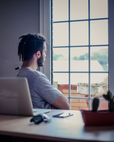 A man gazing out a window, reflecting on his healing journey—symbolizing the deep work of trauma therapy in Los Angeles and the process of finding clarity and emotional balance.