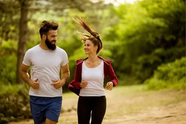 Couple jogging on a trail near Los Angeles, using movement and breath to regulate stress and energy.