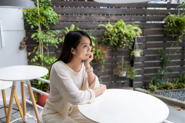 Person sitting quietly at a table during stress, showing withdrawal and reduced engagement as a nervous system response